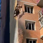 Пошкоджений 10-ти поверховий житловий будинок у Сумах після влучання російського ударного дрона на рівні 4-го поверху